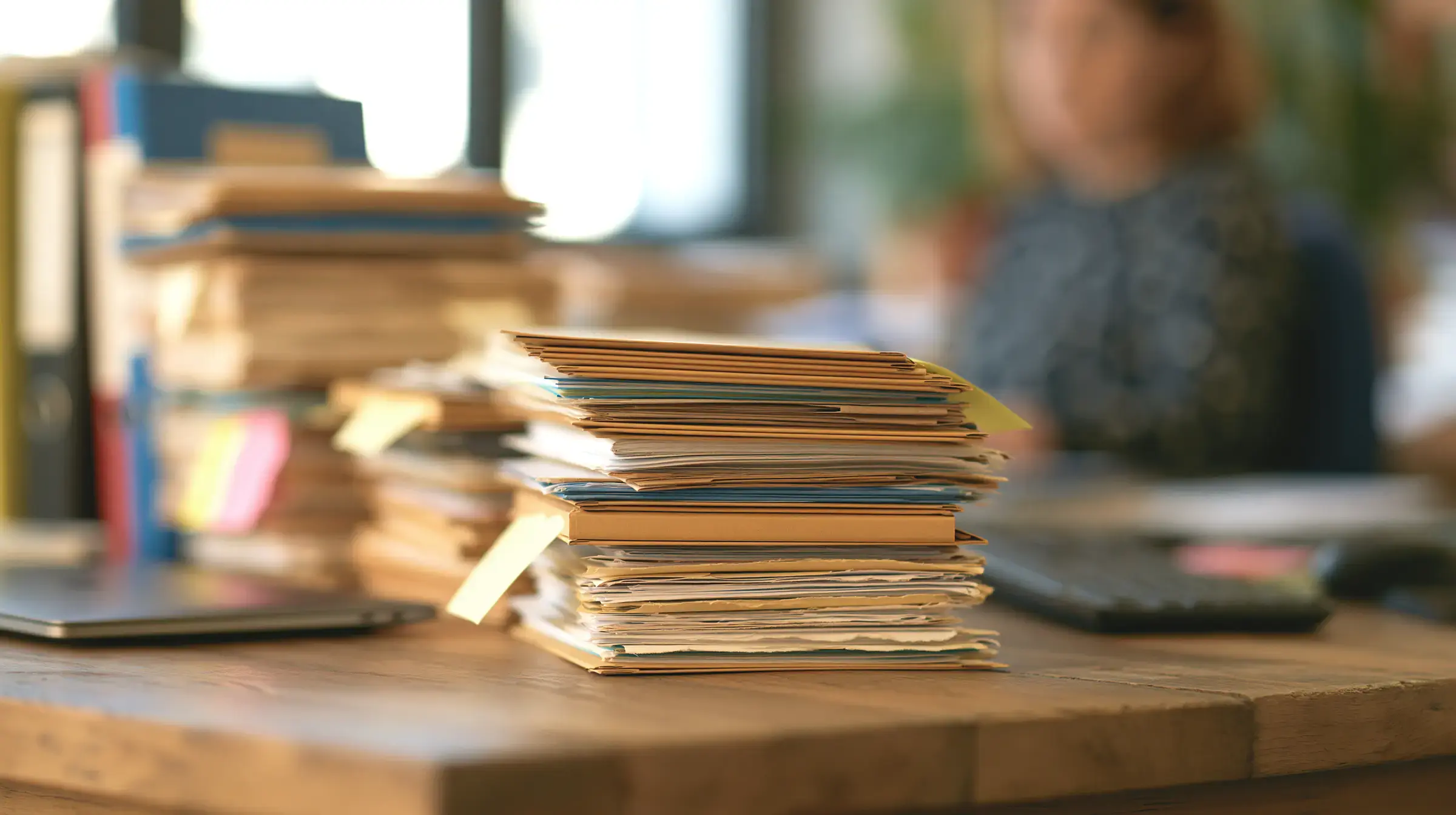 Stacked paper case files on a desk – the manual records Fisar replaces